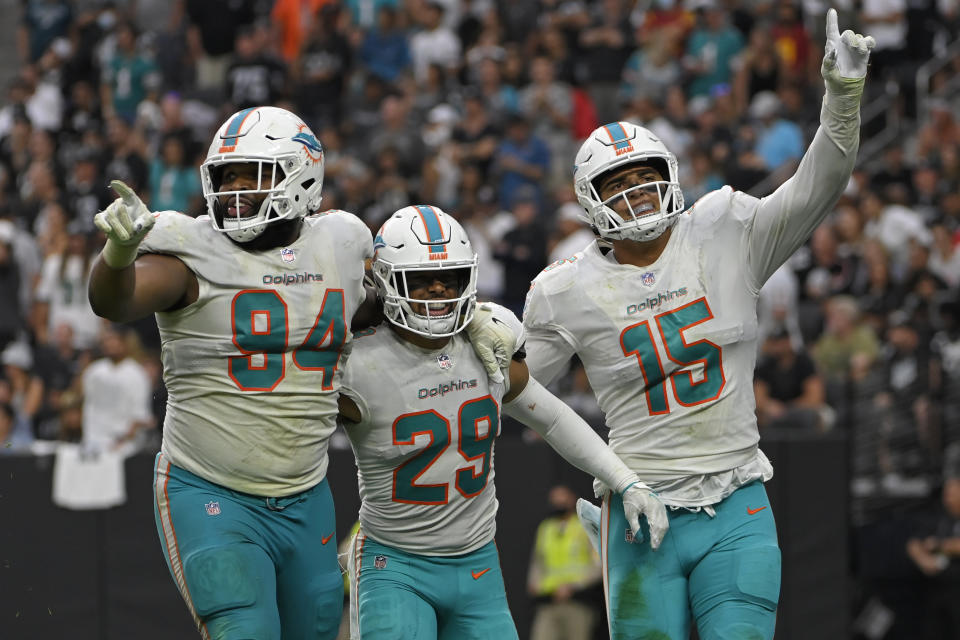 Miami Dolphins defensive end Christian Wilkins (94) and linebacker Jaelan Phillips (15) react after defensive back Brandon Jones (29) sacked Las Vegas Raiders quarterback Derek Carr (4) during the second half of an NFL football game, Sunday, Sept. 26, 2021, in Las Vegas. (AP Photo/David Becker)