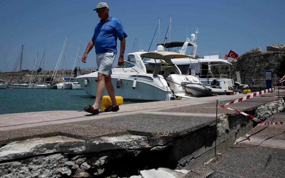 A man walks along the damaged pier of the port of Kos - Credit: COSTAS BALTAS/Reuters