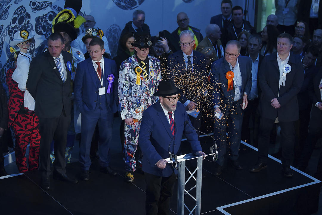 George Galloway, foreground, has confetti thrown at him by Just Stop Oil protestors as he gives a speech after being declared winner in the Rochdale by-election, which was triggered after the death of Labour MP Sir Tony Lloyd, in the town of Rochdale, England Thursday, Feb. 29, 2024. (Peter Byrne/PA via AP)