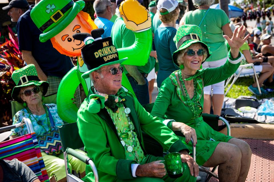 Dave and Susie Walsh wave to parade participants while they sit with their blow up Paddy during the Naples St. Patrick's Day Parade downtown on Saturday, March 16, 2019. 