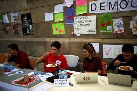 Students sit outside the University of Barcelona, informing citizens where they can vote in the banned October 1 independence referendum, in Barcelona, Spain, September 25, 2017. REUTERS/Jon Nazca