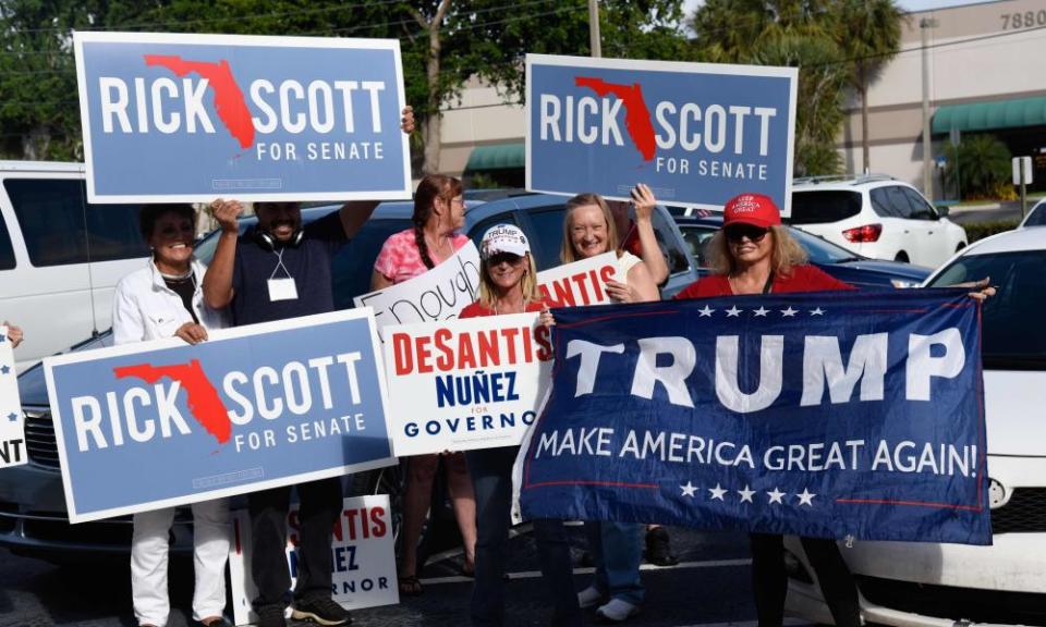 Republican supporters hold signs in West Palm Beach, Florida, with tense recounts under way.