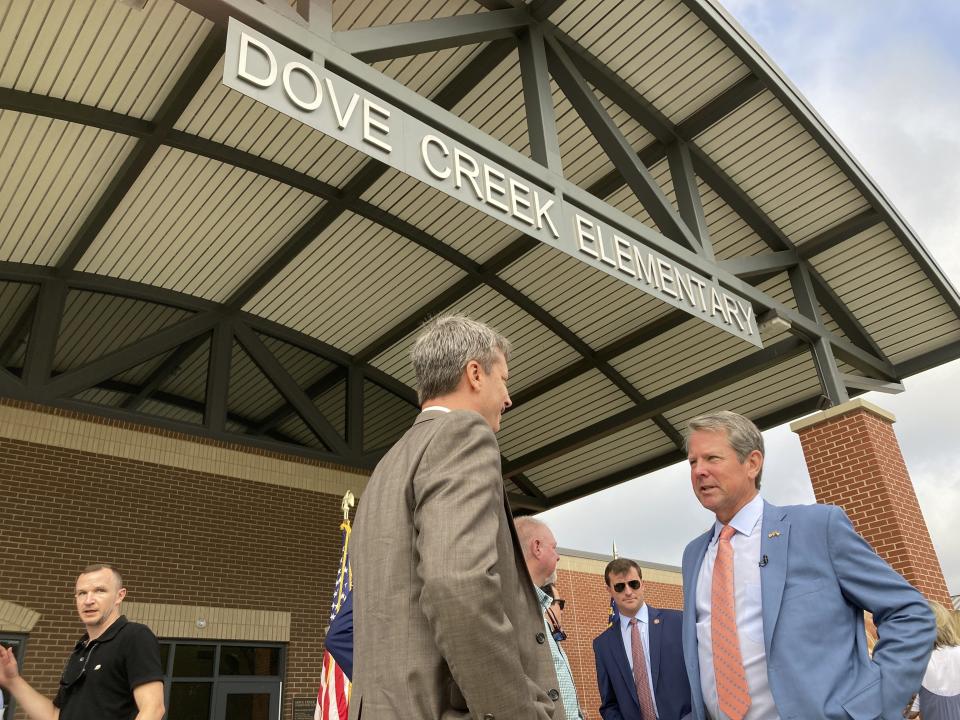 FILE - Georgia Gov. Brian Kemp, right, speaks to an Oconee County school administrator after announcing K-12 priorities for his second term at a reelection campaign event at Dove Creek Elementary School in Statham, Ga., on Monday, Sept. 12, 2022. The Republican wants to give $25 million in grants to help improve student academic performance. (AP Photo/Jeff Amy, File)