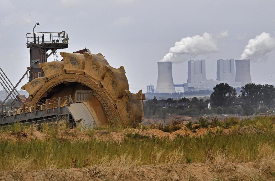 FILE - In this Aug. 27, 2018 file photo a bucket wheel digs for coal near the Hambach Forest near Dueren, Germany. Germany's greenhouse gas emissions fell sharply last year, putting the country's 2020 climate goal within reach again. The state governors Dietmar Woidke of Brandenburg, Michael Kretschmer of Saxony, Reiner Haseloff of Saxony-Anhalt and Armin Laschet of North Rhine-Westphalia meet in Berlin for the adoption by the Bundestag and Bundesrat of the laws on coal phase-out and structural strengthening in the affected federal states. (AP Photo/Martin Meissner)