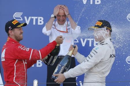 Formula One - F1 - Russian Grand Prix - Sochi, Russia - 30/04/17 - Winner and Mercedes Formula One driver Valtteri Bottas (R) of Finland and second-placed Ferrari Formula One driver Sebastian Vettel of Germany spray champagne as Mercedes Race Engineer Tony Ross reacts on the podium. REUTERS/Maxim Shemetov