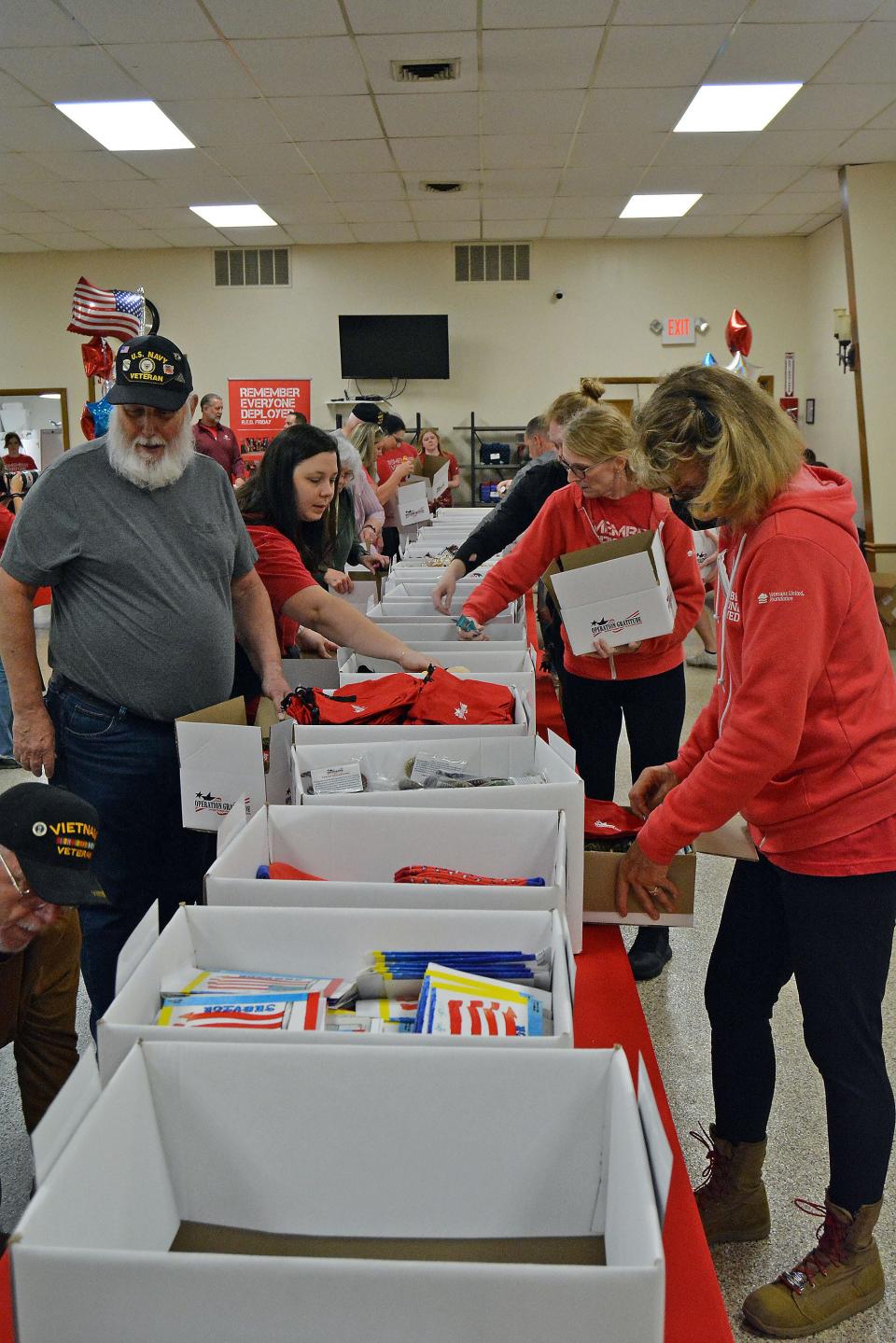 Retired veterans and Veterans United Home Loan employees prepare care kits Thursday for currently deployed troops at Columbia American Legion Post 202.