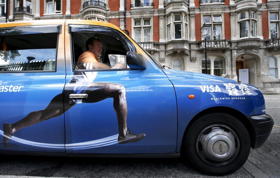 In this Wednesday, Aug. 8, 2012 photo, taxi driver Richard Meid waits for a fare in front of the British Museum during the 2012 Summer Olympics, in London. (AP Photo/Jae C. Hong)