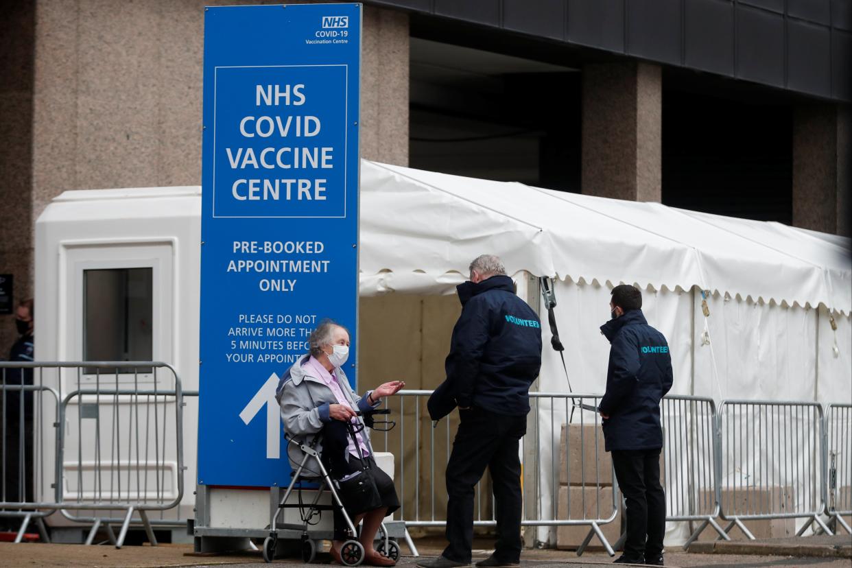 <p>An elderly woman waits outside a vaccination centre after receiving her Covid-19 vaccine in Wembley</p> (REUTERS)