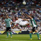 Real Madrid's James Rodriguez (C) scores his second goal between Real Betis' Juan Vargas (L) and Rafael Van der Vaart during their Spanish first division soccer match at Santiago Bernabeu stadium in Madrid, Spain, August 29, 2015. REUTERS/Andrea Comas