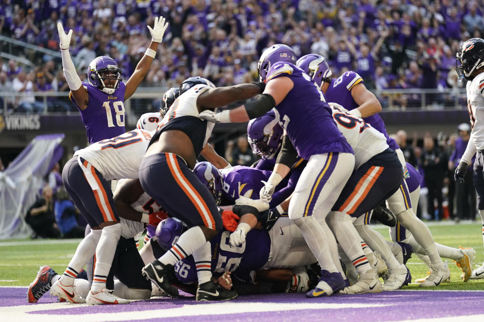 Minnesota Vikings quarterback Kirk Cousins, center, scores on a 1-yard touchdown run during the second half of an NFL football game against the Chicago Bears, Sunday, Oct. 9, 2022, in Minneapolis. (AP Photo/Abbie Parr)