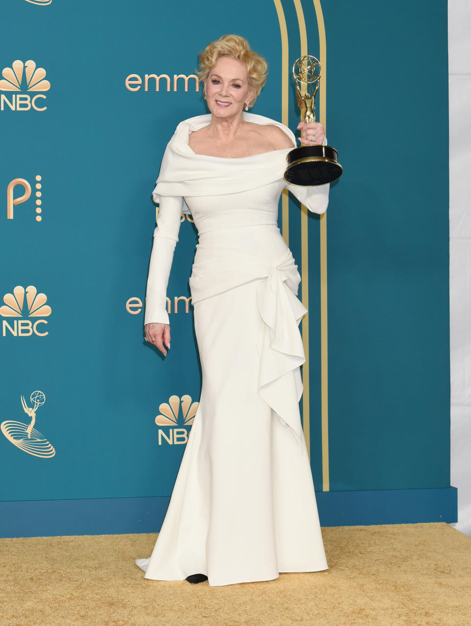 Jean Smart in an off-shoulder gown holding an award at the Emmys