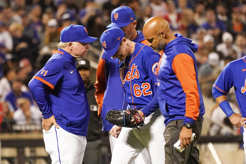 New York Mets pitcher Drew Smith (62) walks off the field with with manager Buck Showalter, left, during the seventh inning of a baseball game against the Philadelphia Phillies, Sunday, May 29, 2022, in New York. (AP Photo/Mary Altaffer)