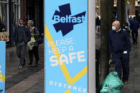 A man wears a face mask in Belfast city centre, Northern Ireland, Wednesday, Oct. 14, 2020. Northern Ireland introducing the tightest COVID-19 restrictions in the United Kingdom on Wednesday, closing schools for two weeks and pubs and restaurants for a month. “This is not the time for trite political points," First Minister Arlene Foster told lawmakers at the regional assembly in Belfast. “This is the time for solutions." (Brian Lawless/PA via AP)