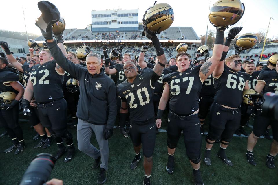 Army head coach Jeff Monken celebrates with captains Marquel Broughton (20) and Connor Bishop (57) after a home-finale win over Connecticut on Saturday. DANNY WILD/USA TODAY Sports