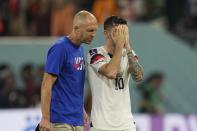 Head coach Gregg Berhalter of the United States, left, walks with Christian Pulisic after the World Cup round of 16 soccer match between the Netherlands and the United States, at the Khalifa International Stadium in Doha, Qatar, Saturday, Dec. 3, 2022. The Netherlands won 3-1. (AP Photo/Martin Meissner)