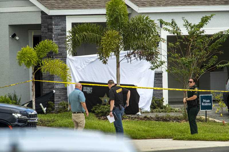 Polk County Sheriff's investigators work the scene in Davenport, Florida, where three workers were attacked.