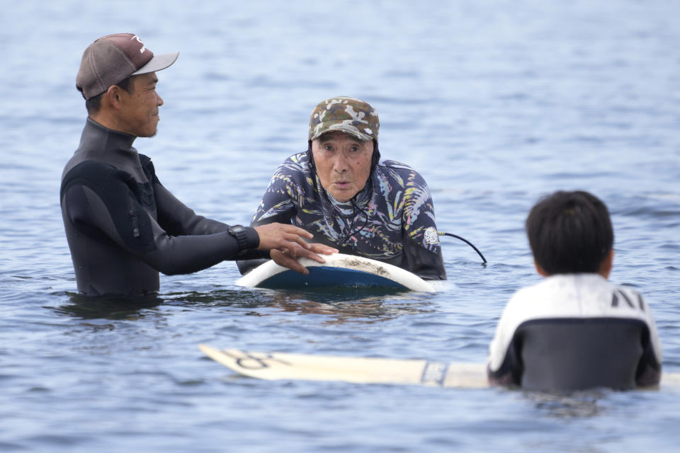 Seiichi Sano, an 89-year-old Japanese man, receives a surfing lesson from surf coach Kazuto Shimizu at Katase Nishihama Beach, Thursday, March 30, 2023, in Fujisawa, south of Tokyo. Sano, who turns 90 later this year, has been recognized by the Guinness World Records as the oldest male to surf. (AP Photo/Eugene Hoshiko)