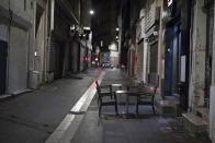 Tables sit empty in Marseille, southern France, Saturday, Oct. 17, 2020. France is deploying 12,000 police officers to enforce a new curfew that came into effect Friday night for the next month to slow the virus spread, and will spend another 1 billion euros to help businesses hit by the new restrictions. (AP Photo/Daniel Cole)