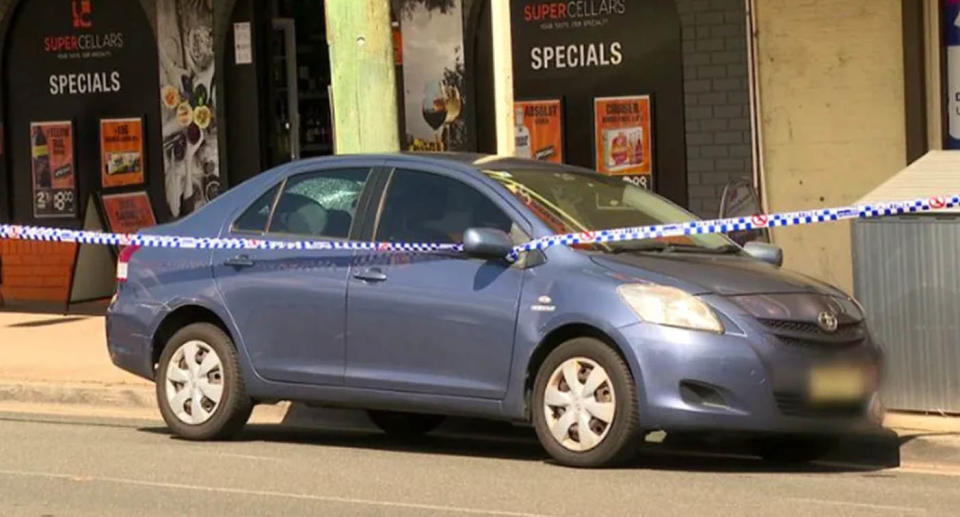 A photo of the car with police tape around it where a three-year-old boy was found dead.