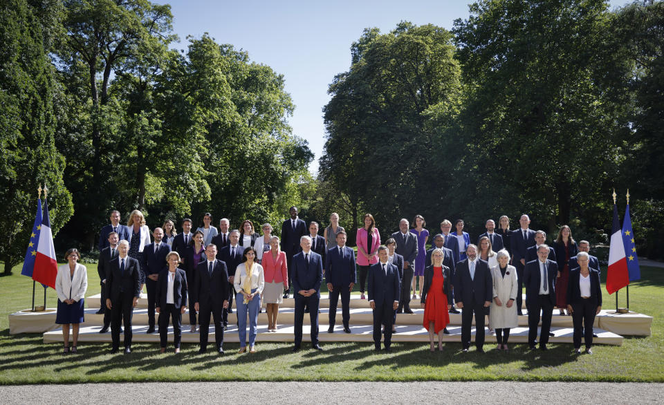 French President Emmanuel Macron, center, poses with minister in the gardens of the Elysee Palace in Paris, Monday, July 4, 2022. French President Emmanuel Macron rearranged his Cabinet on Monday in an attempt to adjust to a new political reality following legislative elections in which his centrist alliance failed to win a majority in the parliament. (Ludovic Marin, Pool via AP)