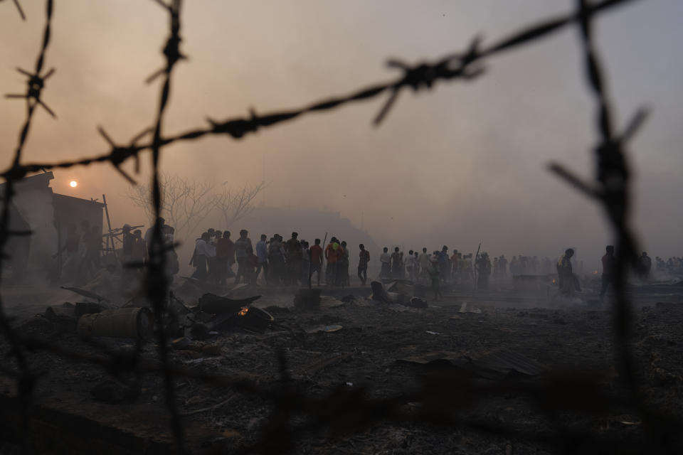 Rohingya refugees look on after a major fire in their Balukhali camp at Ukhiya in Cox's Bazar district, Bangladesh, Sunday, March 5, 2023. A massive fire raced through a crammed camp of Rohingya refugees in southern Bangladesh on Sunday, leaving thousands homeless, a fire official and the United Nations said. (AP Photo/Mahmud Hossain Opu)