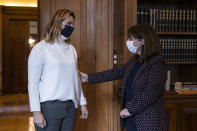 Greek President Katerina Sakellaropoulou welcomes Olympic sailing champion Sofia Bekatorou, left, at the Presidential Palace in Athens, Monday, Jan. 18, 2021. Bekatorou has accused an unnamed sporting official of sexually assaulting her in 1998 during preparations for the Sydney Games. Bekatorou made the allegation Thursday Jan. 14, 2021 while speaking at an online event organized by the ministry of culture and sport. (Alkis Konstantinidis /Pool via AP)