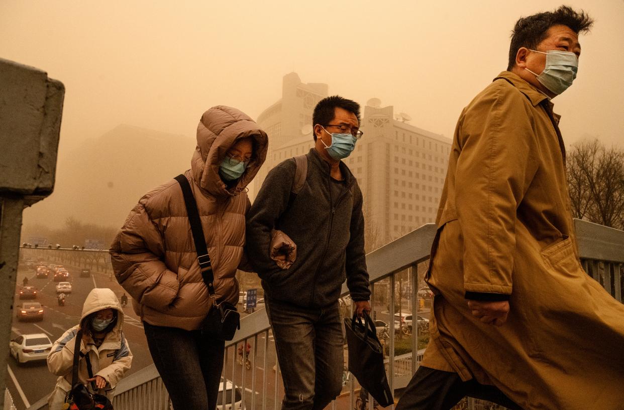 <p>People wear protective masks as they commute during a sandstorm in Beijing</p> (Getty)