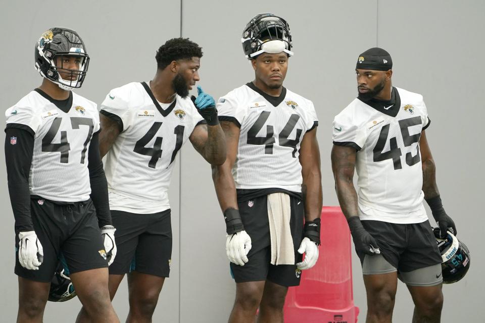 Jacksonville Jaguars defensive players, from left, DeShaan Dixon (47), Josh Allen (41), Travon Walker (44) and K'Lavon Chaisson (45) talk on the sideline during a scrimmage at an NFL football practice, Tuesday, May 31, 2022, in Jacksonville, Fla. (AP Photo/John Raoux)