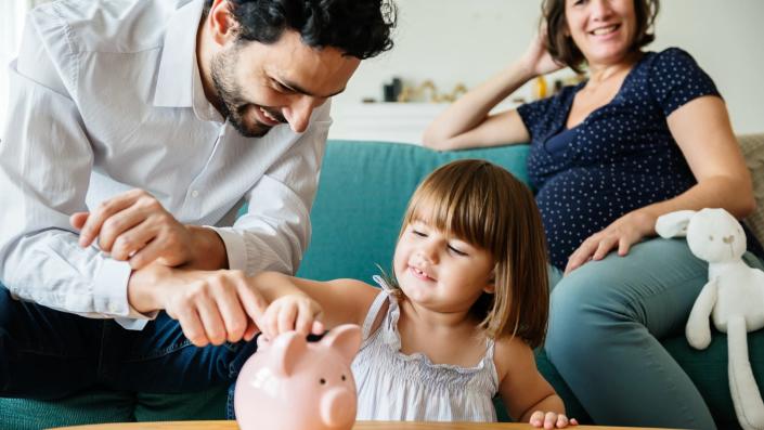 Family saving money in piggy bank.