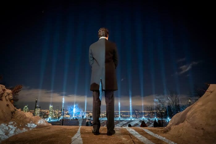 Prime Minister Justin Trudeau stands in front of the 14 beams of light.