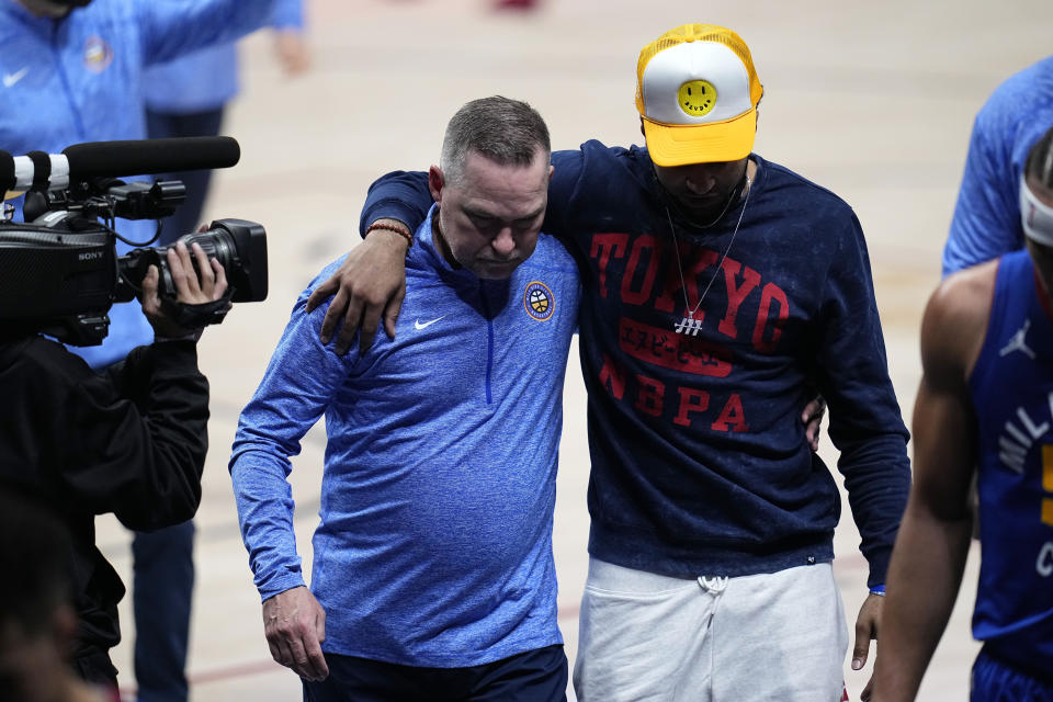 Denver Nuggets coach Michael Malone and Jamal Murray hug as they leave the court after the team's loss to the Portland Trail Blazers in Game 1 of a first-round NBA basketball playoff series Saturday, May 22, 2021, in Denver. (AP Photo/Jack Dempsey)