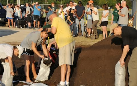 St Johns County Florida residents wait for the arrival of sandbags - Credit:  Bob Self/AP