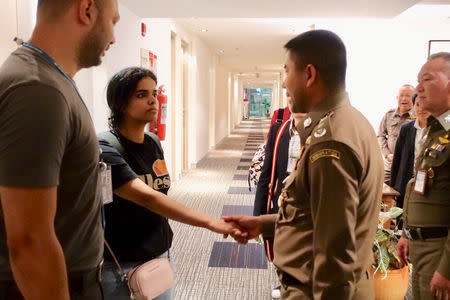 Saudi teen Rahaf Mohammed al-Qunun is greeted by Thai immigration authorities at a hotel inside Suvarnabhumi Airport in Bangkok, Thailand January 7, 2019. Thailand Immigration Police via REUTERS/Files