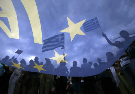 Pro-Euro protesters hold Greek national flags during a pro-Euro rally in front of the parliament building, in Athens, Greece, June 30, 2015. REUTERS/Yannis Behrakis