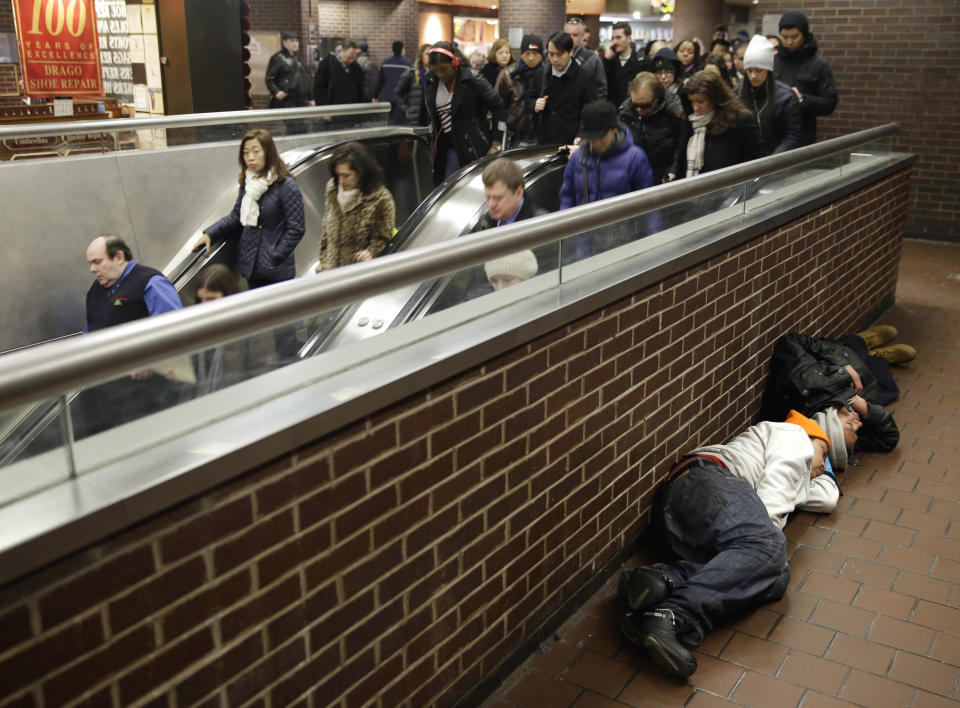 FILE — In this Mach 19, 2015 file photo, two men sleep on the floor of the Port Authority Bus Terminal in New York. New York City's main bus terminal, long ridiculed for leaky ceilings, dirty bathrooms and frequent delays, could be in for a major overhaul. The Port Authority of New York and New Jersey unveiled a plan Thursday, Jan. 21, 2021, to rebuild and expand the embattled midtown Manhattan bus terminal. (AP Photo/Seth Wenig, File)