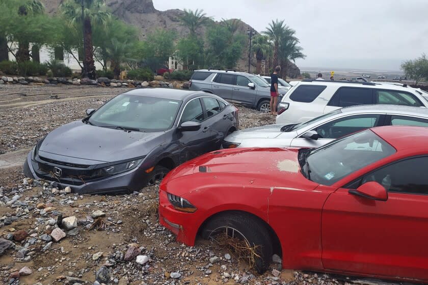 In this photo provided by the National Park Service, cars are stuck in mud and debris from flash flooding at The Inn at Death Valley in Death Valley National Park, Calif., Friday, Aug. 5, 2022. Heavy rainfall triggered flash flooding that closed several roads in Death Valley National Park on Friday near the California-Nevada line. The National Weather Service reported that all park roads had been closed after 1 to 2 inches of rain fell in a short amount of time. (National Park Service via AP)