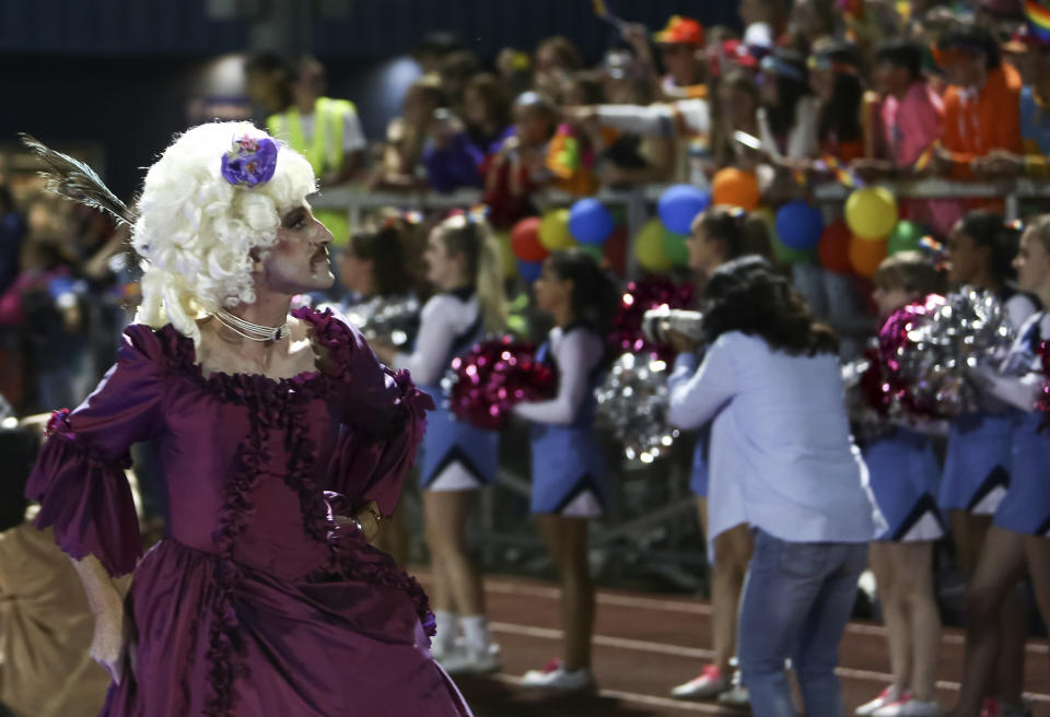 In this photo provided by Fritz Senftleber, people participate in the “drag ball" halftime show at Burlington High School on Friday, Oct. 15, 2021 in Burlington, Vt. The event was part of that school's homecoming and was sponsored by the Gender Sexuality Alliance from Burlington and South Burlington high schools. The football game was between a team made up of students from three Burlington-area schools Burlington, South Burlington and Winooski High Schools who played against St. Johnsbury Academy. (Fritz Senftleber via AP)