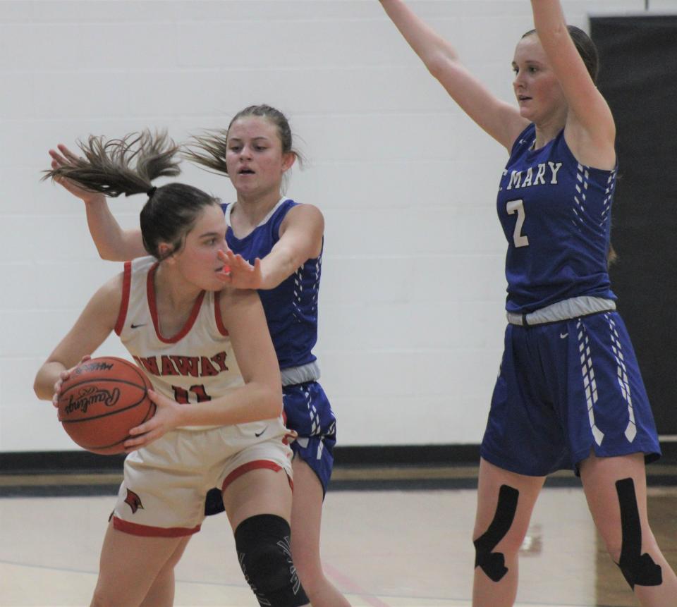 Onaway junior guard Kailyn George (11) looks to make a pass around a Gaylord St. Mary trap during the first half of Wednesday's girls basketball game in Onaway.
