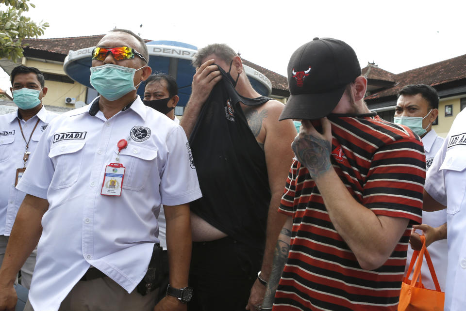 Police officers escort British national Collum Park, right, and Australian national Aaron Wayne Coyle, second from right, to a police car at the regional police headquarters in Denpasar, Indonesia on Thursday, Sept. 3, 2020. Indonesian police say the men have been arrested with methamphetamine and ecstasy pills on the tourist island of Bali. (AP Photo/Firdia Lisnawati)