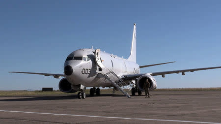 A member of the U.S. Navy stands next to the Boeing P-8A Poseidon plane before its departure to take part in the search for the ARA San Juan submarine missing at sea, at a military air base in Bahia Blanca, Argentina November 22, 2017. Picture taken November 22, 2017. REUTERS/Magali Cervantes