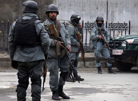 Afghan policemen stand at the site of a suicide attack in Kabul February 26, 2015. REUTERS/Mohammad Ismail