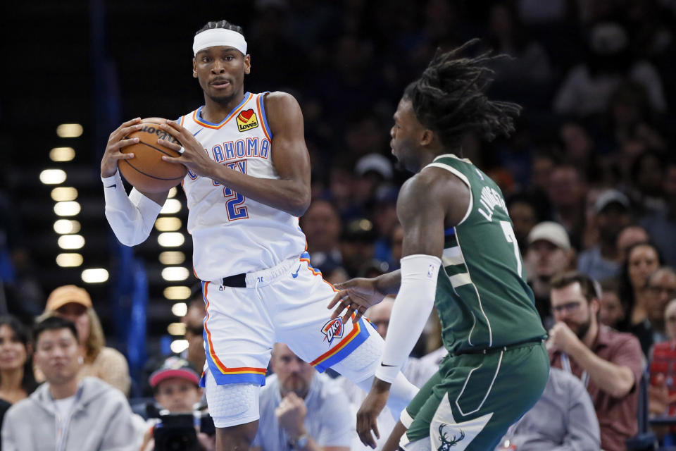 Oklahoma City Thunder guard Shai Gilgeous-Alexander (2) grabs a rebound next to Milwaukee Bucks forward Chris Livingston (7) during the second half of an NBA basketball game Friday, April 12, 2024, in Oklahoma City. (AP Photo/Nate Billings)