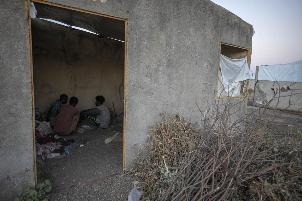 Ethnic Amhara refugees who fled Mai-Kadra, Ethiopia, sit inside their temporary shelter in an area separated from ethnic Tigrayan refugees, at Village 8, the transit center near the Lugdi border crossing, eastern Sudan, Sunday, Dec. 6, 2020. Witnesses in Mai-Kadra told the Ethiopian Human Rights Commission and Amnesty International that Tigrayan forces and allies attacked Amhara. But others say it was the other way around: Tigrayans were targeted by Ethiopian federal forces and allied Amhara regional troops. (AP Photo/Nariman El-Mofty)