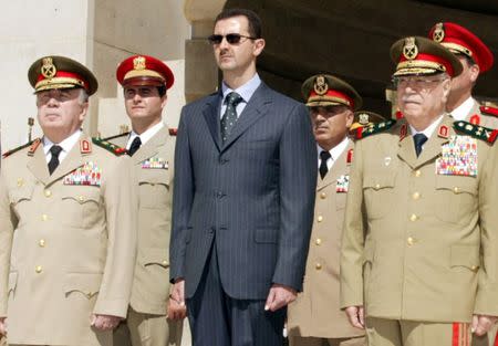 Syrian President Bashar al-Assad (C) new Defence Minister Hassan Turkmani (L) and former Defence Minister Mustafa Tlass attend a ceremony at the unknown soldier monument in Damascus, Syria October 6, 2003. SANA/Handout via REUTERS/File Photo