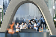 Visitors pray in front of the cenotaph dedicated to the victims of the atomic bombing at the Hiroshima Peace Memorial Park in Hiroshima, western Japan Friday, Aug. 6, 2021. Hiroshima on Friday marked the 76th anniversary of the world's first atomic bombing of the city. (Kyodo News via AP)