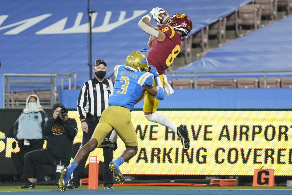 Southern California wide receiver Amon-Ra St. Brown (8) catches a pass in the end zone for a touchdown while defended by UCLA defensive back Rayshad Williams (3) during the fourth quarter of an NCAA college football game Saturday, Dec 12, 2020, in Pasadena, Calif. (AP Photo/Ashley Landis)