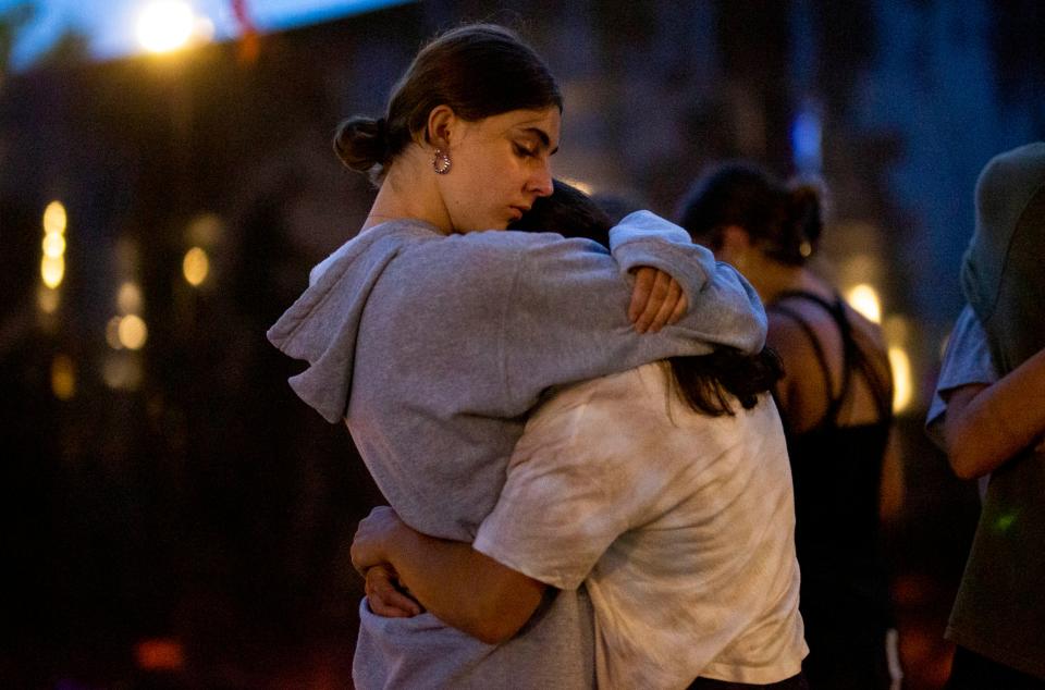 People gather for a candlelight vigil July 5 near where seven people were killed by a gunman at a Fourth of July parade in Highland Park, Ill.