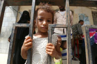 A girl stands behind a fence at a school to which she and her family have been evacuated from a village near Hodeidah airport amid fighting between government forces and Houthi fighters in Hodeidah, Yemen June 17, 2018. REUTERS/Abduljabbar Zeyad