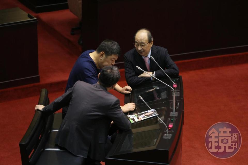 立委對峙時，民進黨立委鄭運鵬（背對者）帶著本週《鏡週刊》進場。