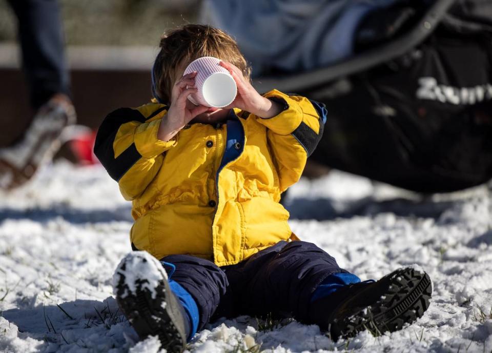 Desmond Lore, 1, drinks hot cider mixed with snow in Charlotte, N.C., on Saturday, January 22, 2022. Charlotte could see another inch or more of snow on Friday night, Jan. 28, 2022, a National Weather Service meteorologist said.